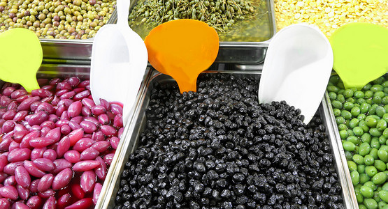 托盘充满黑色和绿色橄榄和其他有机产品, 如红洋葱出售在一个地中海国家的市场摊位