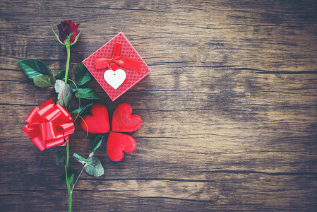 情人节礼品盒红色在木头背景/红色心脏情人节红色玫瑰花和礼物箱子丝带弓在老木头-爱概念顶视图拷贝空间