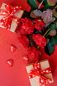 roses摄影照片_Beautiful bouquet of roses with a gift boxes on a red background, St. Valentine's Day , 8 March and Mother's Day concept
