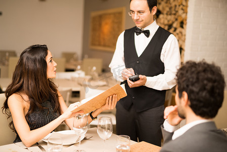 点菜单饭店摄影照片_夫妇在餐厅点菜