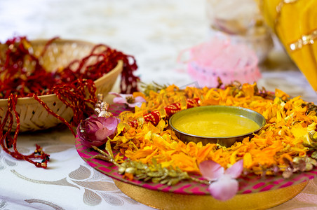 印度婚礼摄影照片_传统的哈尔迪姜黄保存在一个花盘上为印度的婚礼