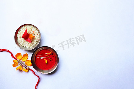 Raksha bandhan rakhi 与花、米和 kumkum、raksha bandhan 或 Rakshabandhan 在白色背景上拍摄印度节日的顶视图