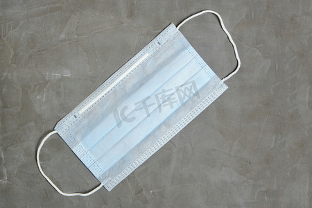 face摄影照片_Medical face mask on a gray background