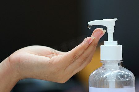 伸出手摄影照片_在医疗保健概念中，当人们为了保护自己不受细菌和白种人感染而伸出手来的时候，用酒精凝胶瓶洗手.