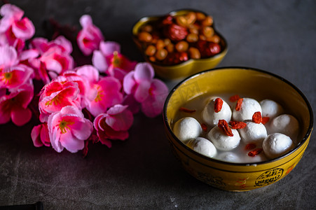 tangyuan摄影照片_Tangyuan, peanuts, dates, Wolfberry and flowers on the table