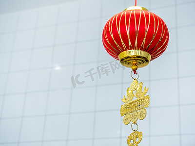 红色文字背景摄影照片_红色的中式吊灯挂在白色房间的背景上，带有复制空间，是中国新年的装饰品。1.灯笼上的文字是用来问安的.