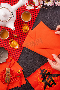 期货持仓摄影照片_中国农历新年的设计理念- -妇女持仓，送红包（红包，红包）以换取好运，顶视图，平铺，头顶上方。