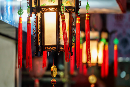 中国红色花边摄影照片_在中国的新年庆祝活动上，用红色的花边挂在户外，点着老式节庆灯笼。假日装饰和街道照明