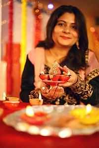 图片说明一位身穿传统服装、身穿华丽背景装饰的印度美女在迪瓦利的肖像工作室庆祝迪瓦利节的肖像.