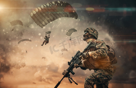 军队管酒治酒摄影照片_在被摧毁的城市上空的烟雾之间有降落伞的军队
