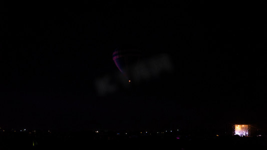 闪烁热点摄影照片_热气球在壮观的卡帕多西亚上空盘旋，在夜空中闪烁着银河般的光芒和夜晚的星星  