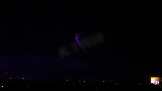 热气球在壮观的卡帕多西亚上空盘旋，在夜空中闪烁着银河般的光芒和夜晚的星星  