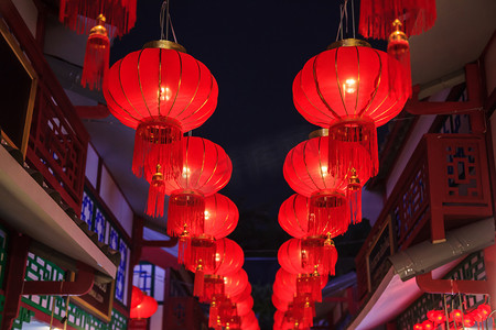 红色金色节日摄影照片_传统的中国红色之夜户外休闲吊灯与金色的传送带装饰装饰路灯, 建筑物和商店为中国新年节日季节庆祝活动