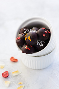 用燕麦片、核桃和葡萄干制成的巧克力糖果，用白碗包裹着冻干的浆果和椰子。无糖，麸质，乳糖.
