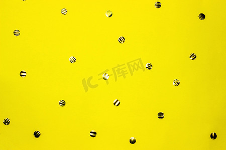 Gold round confetti on yellow background. Festive backdrop. Top view, flat lay.