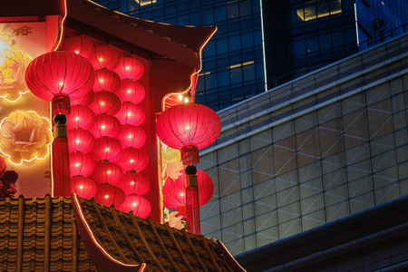 中国的红灯笼，农历新年装饰挂在以建筑为背景的庙宇屋顶上.