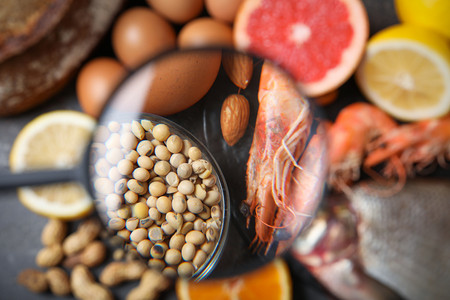 不同产品与放大镜侧重于大豆和虾，特写。食物过敏概念
