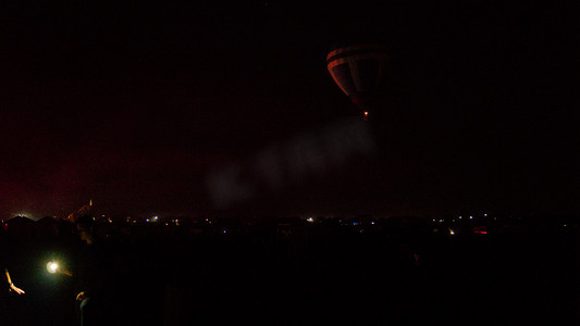 Hot air balloon flying over spectacular Cappadocia under the sky with milky way and shininng star at night (with grain)