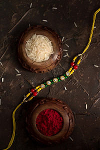 rice摄影照片_Raksha Bandhan背景，有优雅的Rakhi 、 Rice Grains和Kumkum 。 手镯印度传统的腕带，是兄弟姐妹间爱情的象征.