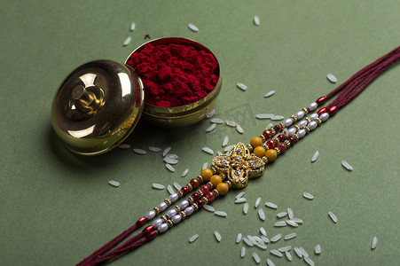 印度节：Raksha Bandhan背景，有优雅的Rakhi 、 Rice Grains和Kumkum 。手镯印度传统的腕带，是兄弟姐妹间爱情的象征.