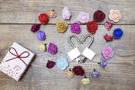 情人节的象征。礼品盒和两个心形锁, 玫瑰在木桌上。顶部视图.