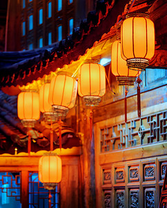 中国红街灯笼挂在雕刻门面的夜景