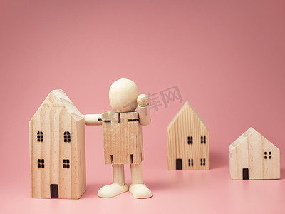 木科摄影照片_木娃娃站在房子旁边。鼓励采取各种措施待在家里。呆在家里.