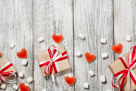 情人节糖果心软糖和工艺纸的礼物盒白色木背景.