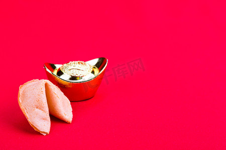 本周热点摄影照片_在红色背景上装饰性金块的幸运饼干