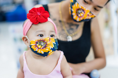 一位可爱的亚洲小女孩戴着美丽的面具，与迷蒙的母亲对抗日冕病毒和空气污染。Coronavirus (Covid-19) and pollution protection for healthcare concept.