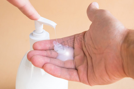 手掌拍摄影照片_液体肥皂瓶和压在饮水机上, 肥皂在手掌上。洗手