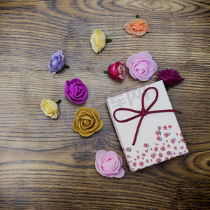 情人节的概念。礼品盒与小组玫瑰在木桌上。具有复制空间的顶部视图