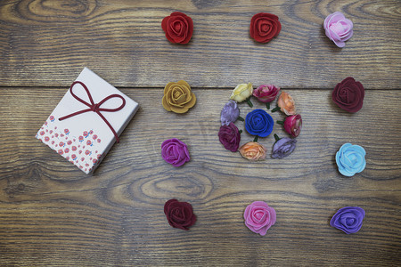 情人节礼品卡的概念。礼品盒与小组玫瑰在木桌上。具有复制空间的顶部视图