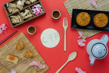 甜饼摄影照片_桌面上观看空中装饰的图片中国中秋节或农历新年背景概念。平卧精餐套餐为甜饼茶歇和红纸花泡茶.