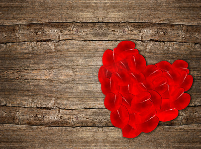 木制背景的心形红玫瑰花瓣