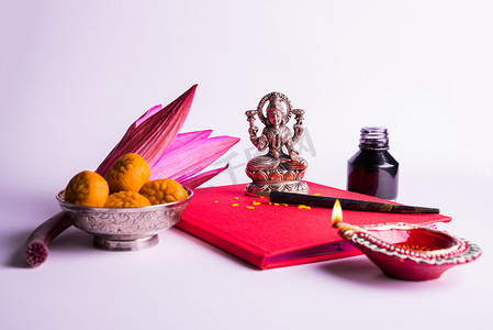 印度财富女神摄影照片_吉祥的印度作品 Shubha Labh 意味着 '善' 与 '财富'，红色会计注书 / '依巴依藏胞' 与女神拉克西米、 迪亚、 糖果和莲花和用笔用墨上拉克西米 pujan，在排灯节