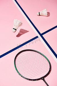 粉色花底纹素材摄影照片_略带蓝色线条的粉色背景羽毛球和球拍