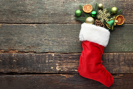 开心铃铛摄影照片_木桌上有圣诞装饰品的红色丝袜