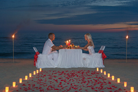 对年轻的夫妇分享一顿浪漫晚餐蜡烛