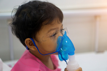 亚洲儿童男孩3岁有病在雾化器面具.