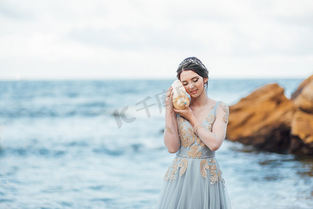 新娘与一个大贝壳在海滩上