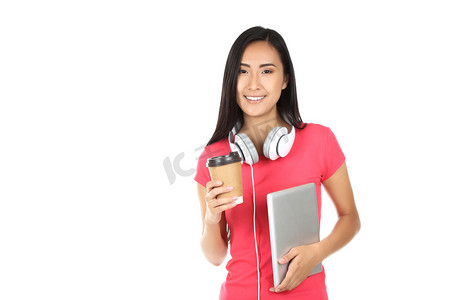 Young woman with tablet pc, headphones and paper cup on white ba