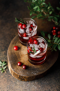 cocktail made with organic gin, white cranberry juice, fresh cranberries, ice and rosemary leaves