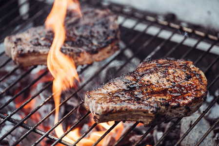火焰牛排摄影照片_多汁美味的牛排烧烤与火焰烧烤级的选择性焦点 