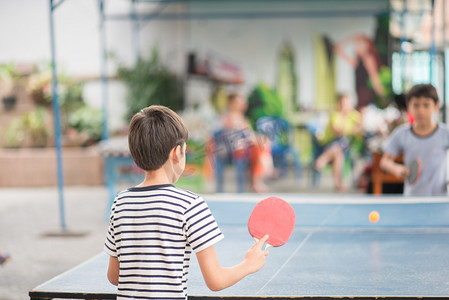 儿童与家人在户外打乒乓球