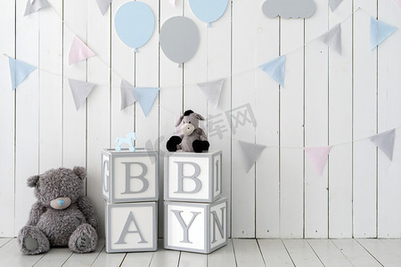 玩具玩具玩具和装饰墙旁边的木制立方体上的文字宝宝，房间里有丑闻式的室内设计。庆祝婴儿淋浴派对的概念