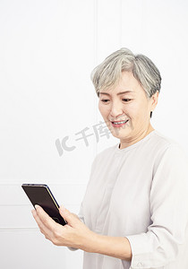 message摄影照片_Happy mature senior asian woman holding smartphone using mobile online apps.