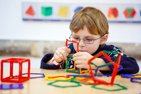 用塑料块建造几何图形的小孩男孩