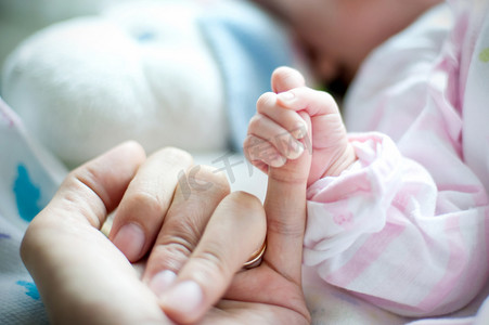 妈妈的手抱着婴儿。照片摄于新生儿妇科