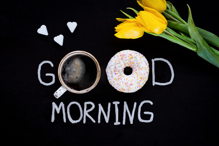 donut摄影照片_Good morning food: glazed donut, cup of black coffee and yellow tulips